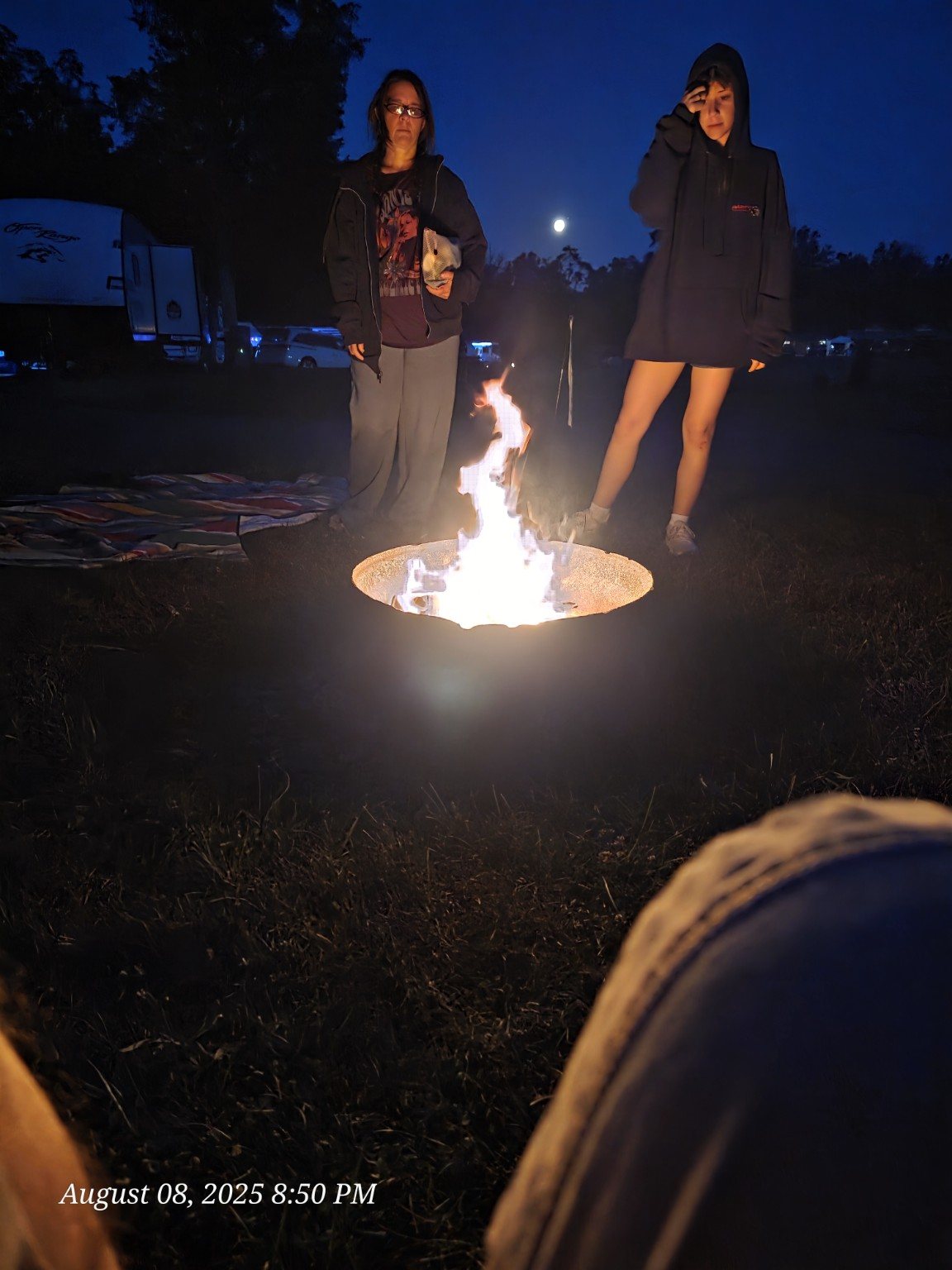 Family gathered around a campfire at night