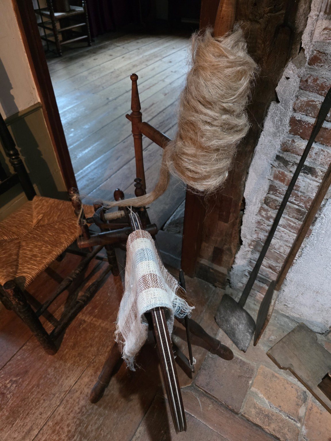 Distaff loaded with fiber beside a small spinning device
