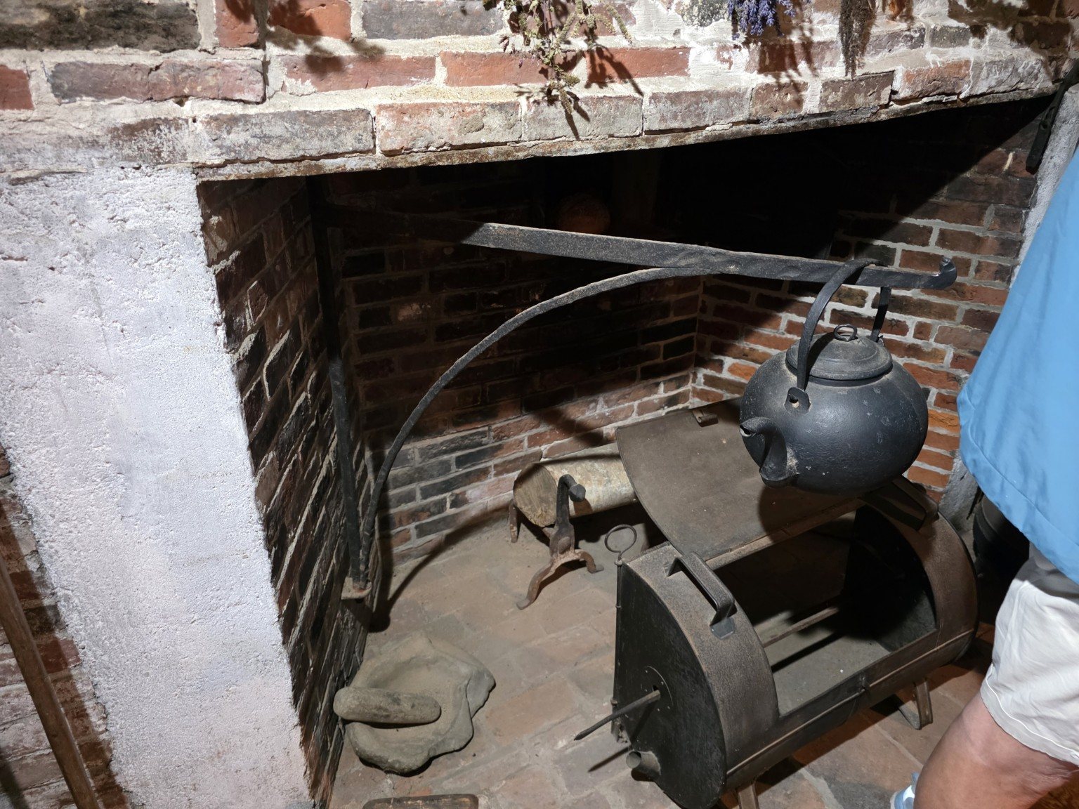 Historic brick cooking hearth with iron kettle and cooking equipment