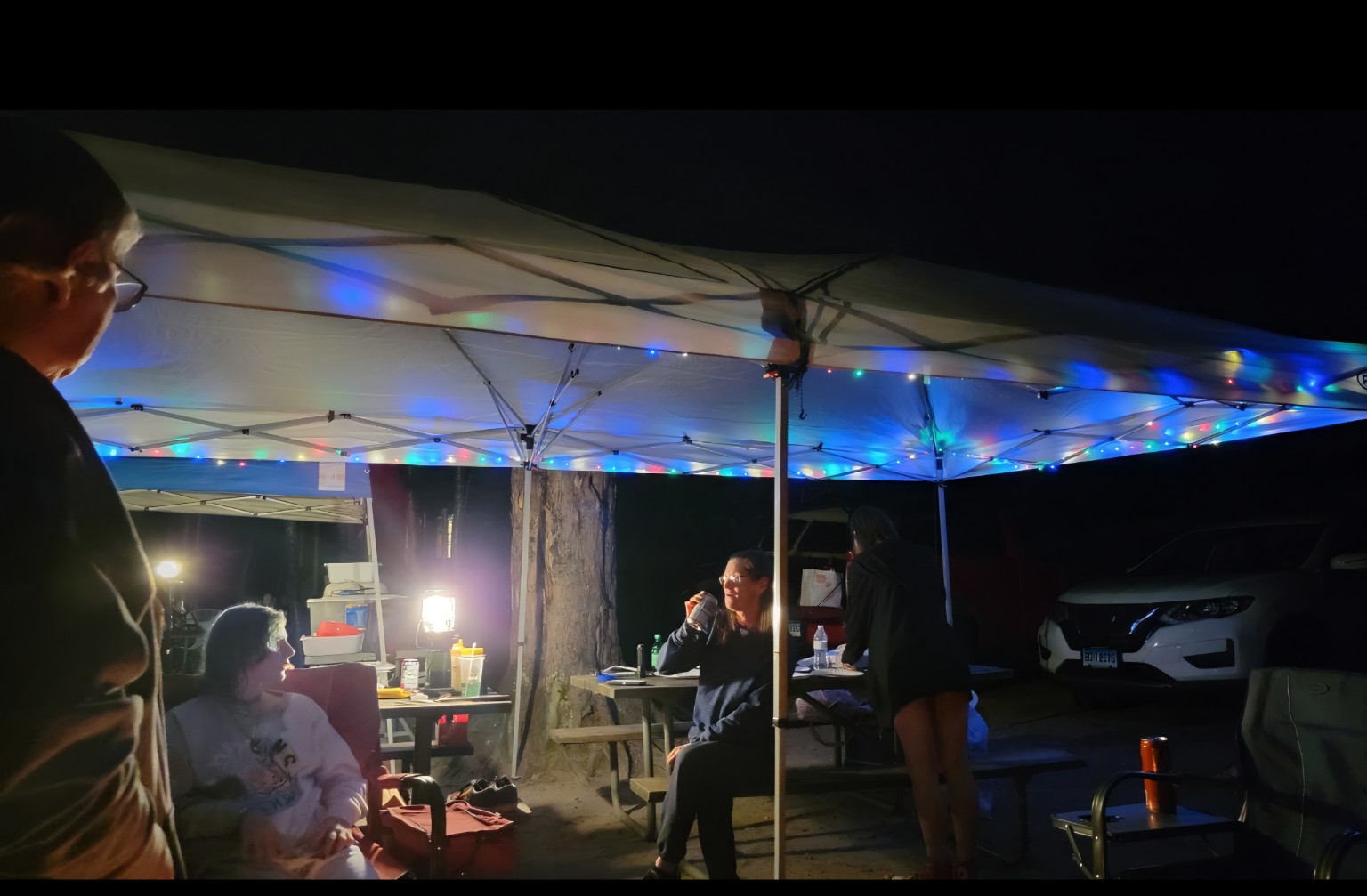 Family gathered beneath lighted canopies at night