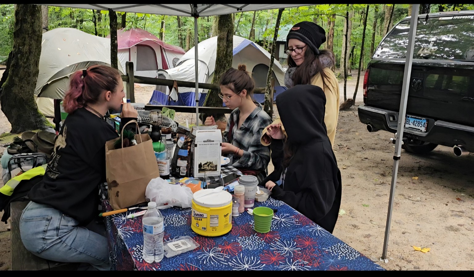 Family members gathered around the campsite picnic table