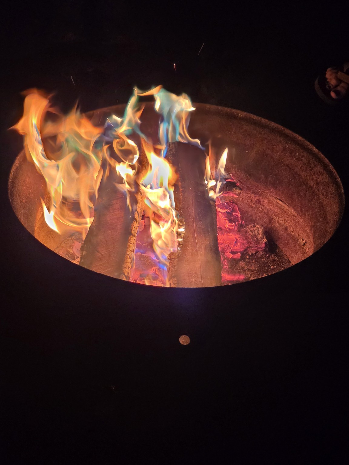 Rainbow campfire glowing after dark