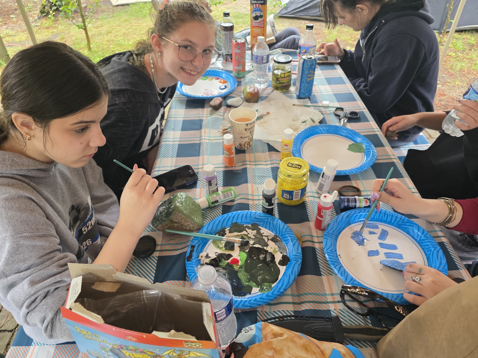 Crew painting rocks at the picnic table