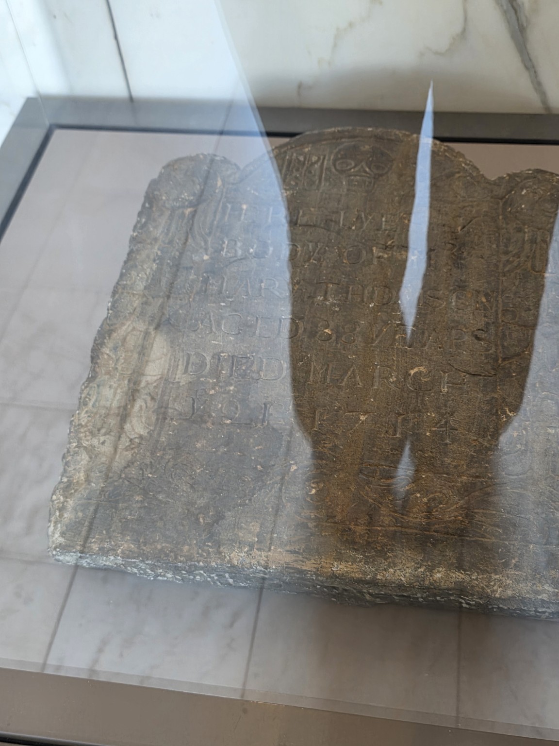 Early New England gravestone with a winged death's head displayed at Pilgrim Hall Museum
