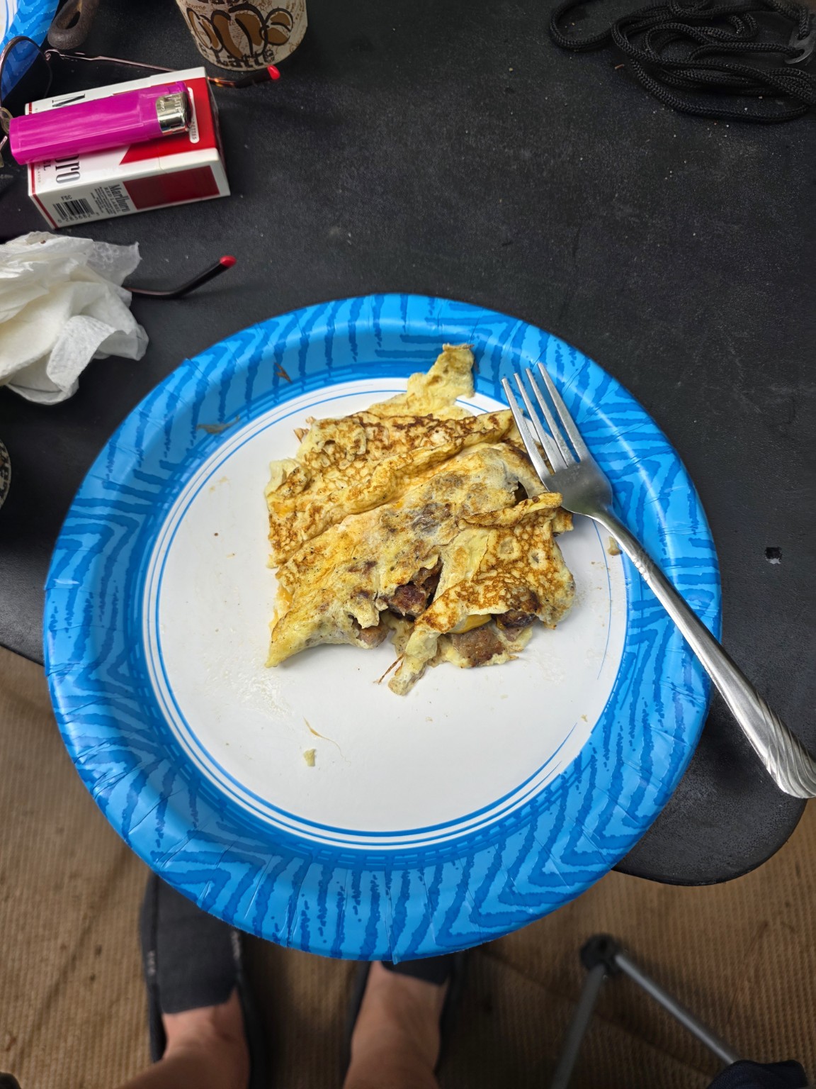 A sausage and cheddar omelet on a blue paper plate