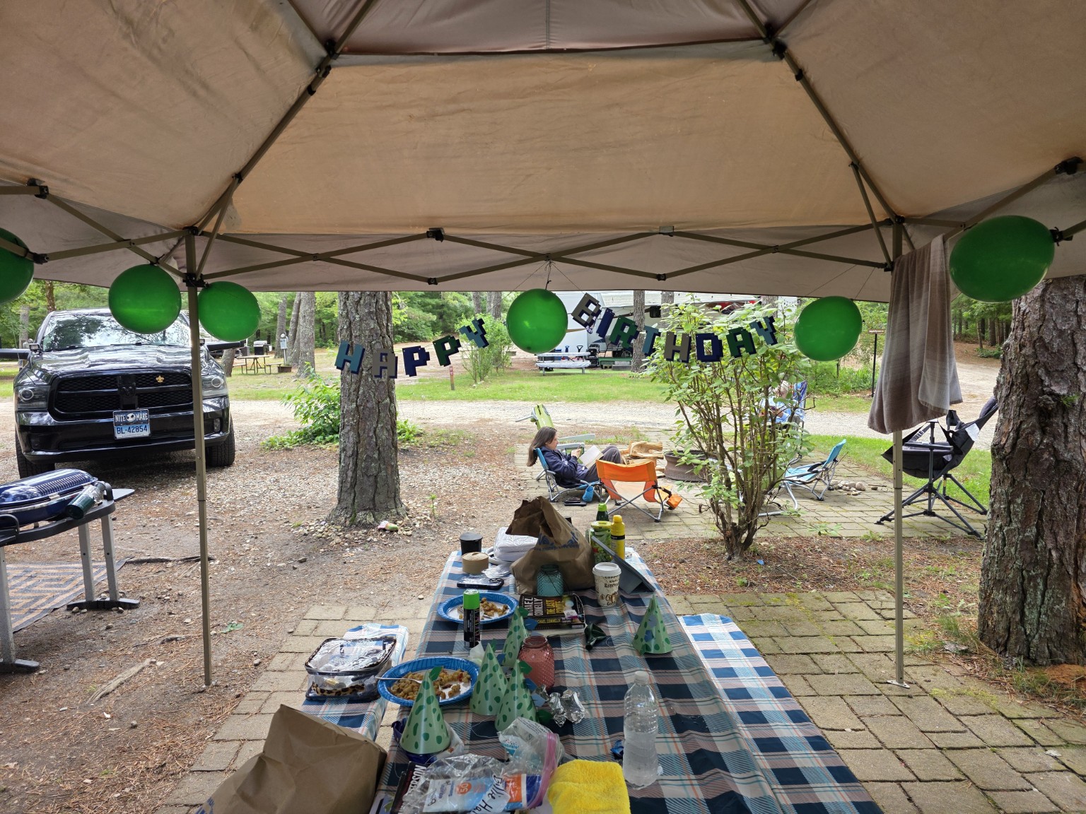 Trail Tater campsite decorated with green balloons, party hats, and a Happy Birthday banner