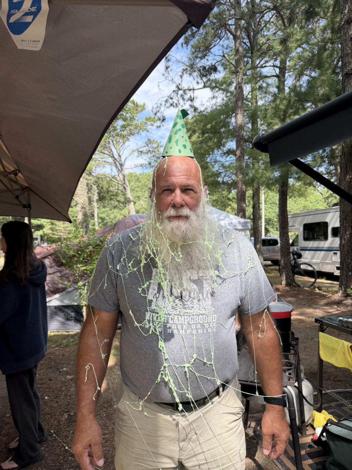 Ken wearing a green party hat and covered in green silly string at the Trail Tater campsite